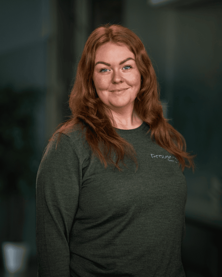 Kvinne i grønt antrekk smiler, bedrift innen innemiljø og ventilasjon.