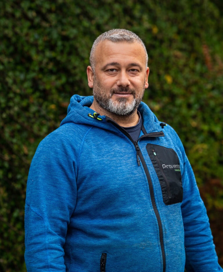 Bilde av mann i blå jakke foran grønt bakgrunn, representerer innemiljøekspertise.